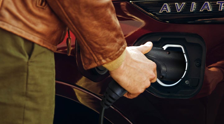 A hand is shown plugging in the charger into the charging port of a 2021 Lincoln Aviator | Klaben Lincoln in Kent OH