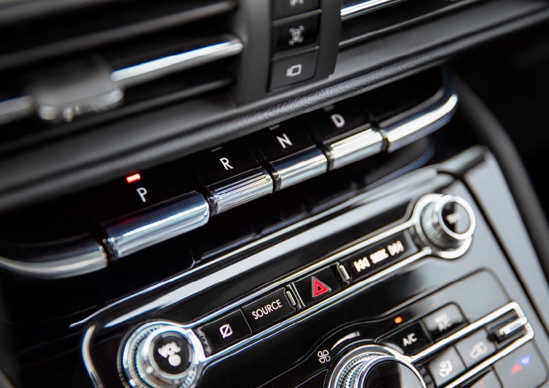 The Park button on the elegant Piano Key Shifter is lit up and engaged as light dances off the chrome accents and horizontal design lines | Klaben Lincoln in Kent OH