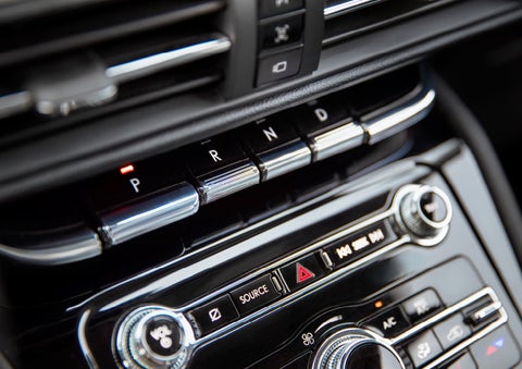 The Park button on the elegant Piano Key Shifter is lit up and engaged as light dances off the chrome accents and horizontal design lines | Klaben Lincoln in Kent OH