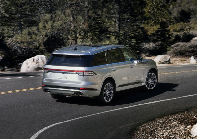 A 2023 Lincoln Aviator® Grand Touring model is shown being driven on a tight turn of a mountain road | Klaben Lincoln in Kent OH