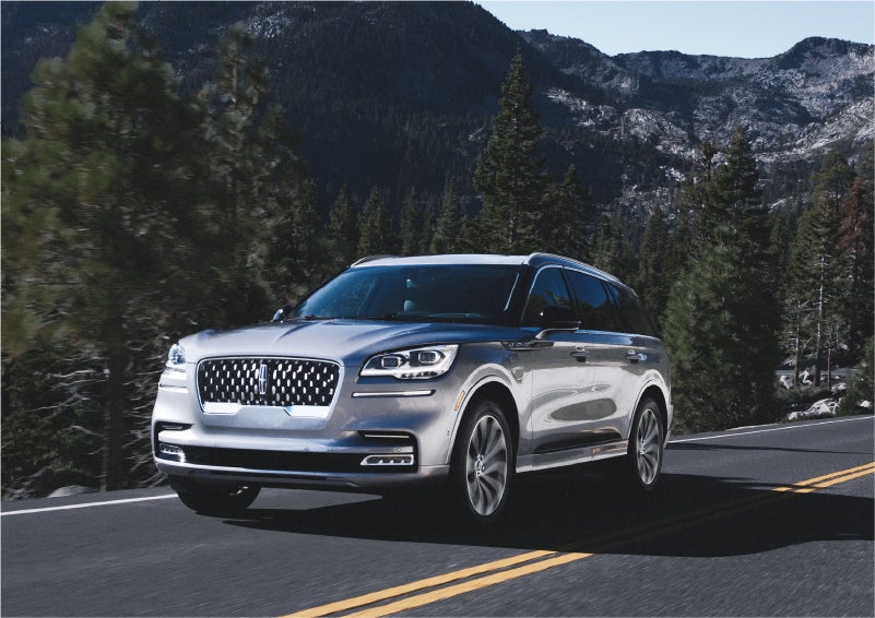 A 2023 Lincoln Aviator® Grand Touring SUV being driven on a winding road to demonstrate the capabilities of all-wheel drive | Klaben Lincoln in Kent OH