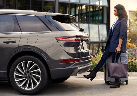 A woman with her hands full uses her foot to activate the available hands-free liftgate. | Klaben Lincoln in Kent OH
