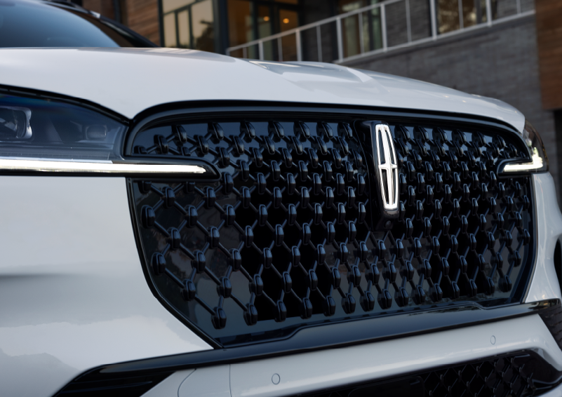 The black grille of a white 2025 Lincoln Aviator® SUV is shown with its fog lights on. | Klaben Lincoln in Kent OH
