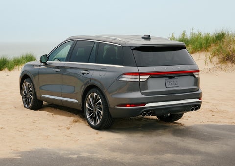 A 2027 Lincoln Aviator® SUV is parked next to sand dunes. | Klaben Lincoln in Kent OH