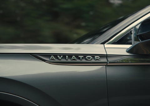 The driver’s side door and fender badging of a gray 2027 Lincoln Aviator® SUV are showcased. | Klaben Lincoln in Kent OH