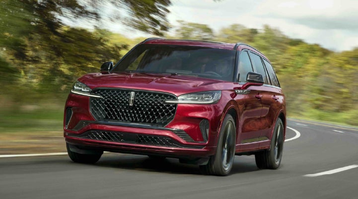 A 2027 Lincoln Aviator® SUV is being driven on a country road | Klaben Lincoln in Kent OH