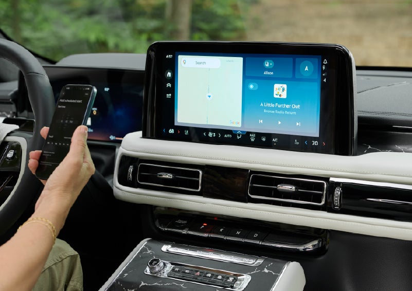 A person pairs thier phone with the center touchscreen of a 2027 Lincoln Aviator® Black Label™ SUV | Klaben Lincoln in Kent OH